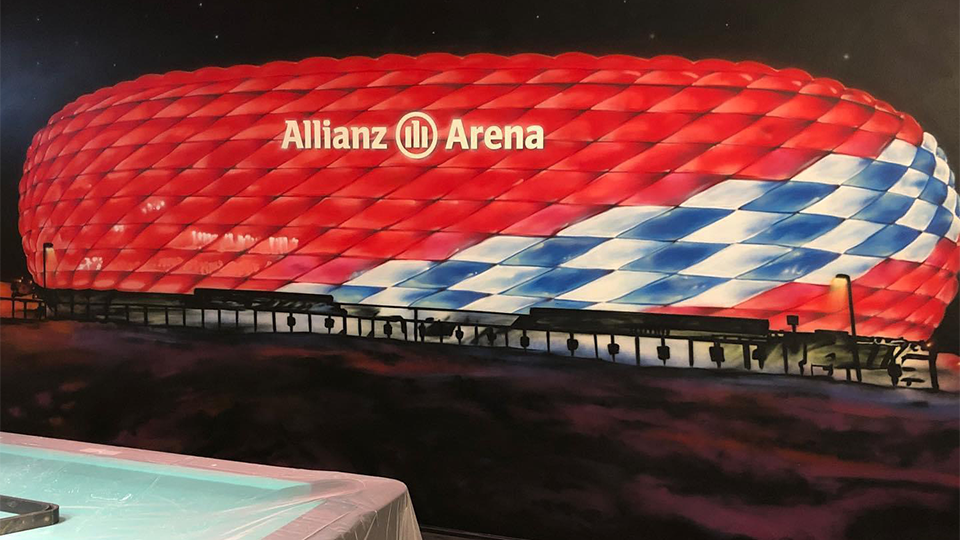 wandgestaltung mit allianz arena im partykeller, billiardraum, detailreich gemaltes fußballstadion mit roter beleuchtung, individuell in münster gestaltet